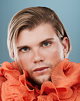 Beauty, lgbtq and face of a man with fashion for self expression, non binary identity and creative style on blue background in studio. Retro, vintage and portrait of queer model in designer clothing