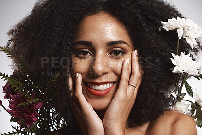 Buy stock photo Portrait, beauty and flowers with a model black woman in studio on a gray background touching her face. Skincare, plant and cosmetics with an attractive young female posing to promote natural care