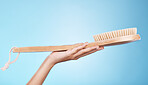 Woman, shower or bath hand brush for cleaning, hygiene and beauty grooming marketing. Model holding spa scrub treatment tool on blue studio background with mockup for cosmetic product.
