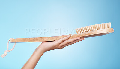 Buy stock photo Woman, shower or bath hand brush for cleaning, hygiene and beauty grooming marketing. Model holding spa scrub treatment tool on blue studio background with mockup for cosmetic product.
