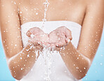 Water splash, cleaning hands and beauty for skincare wellness, cosmetics skin dermatology and luxury hygiene in blue background studio. Model washing, shower water and clean hand or body care glow