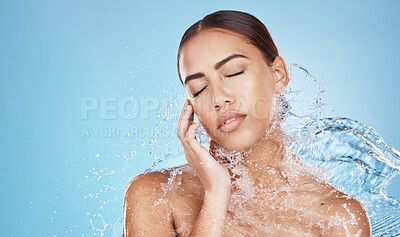 Buy stock photo Woman, hand and water splash for face skincare, dermatology wellness or Brazilian healthcare grooming on blue background studio. Beauty model, water drop or facial cleaning in wet hygiene maintenance