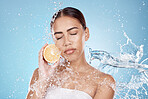 Water splash, orange and natural skincare wellness in blue studio background for organic facial care cleaning, dermatology detox and fruit nutrition. Model face, citrus vitamin c and cosmetics clean