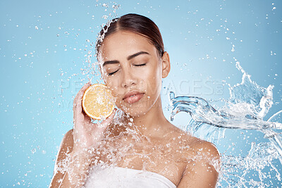 Buy stock photo Water splash, orange and natural skincare wellness in blue studio background for organic facial care cleaning, dermatology detox and fruit nutrition. Model face, citrus vitamin c and cosmetics clean