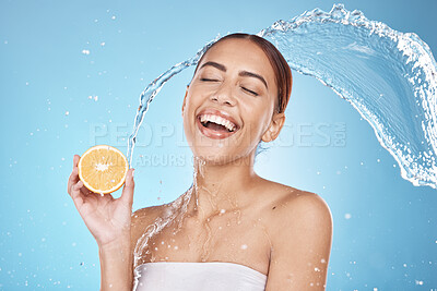 Buy stock photo Water splash, orange fruit and skincare happiness in blue studio background for organic facial care cleaning, dermatology detox and spa nutrition. Model face, smile and vitamin c and citrus cosmetics