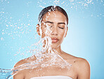 Woman face, skincare grooming or water splash on blue background studio in dermatology wellness, healthcare cleaning or Brazil hygiene maintenance. Beauty model, wet or water drop for facial cleaning