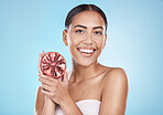 Happy, beauty and portrait of pomegranate model with natural smile and healthy glow for marketing. Skincare, happy and wellness of woman with fruit for cosmetic advertising in blue studio.

