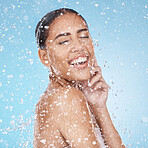 Laughing woman, face skincare or water splash on blue background studio in healthcare wellness, hygiene maintenance or self care grooming. Smile, happy or cleaning beauty model in water drops shower
