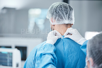 Buy stock photo Surgeon, uniform and theatre clothes for surgery, operation or medical healthcare. Nurse helping doctor with safety scrubs in emergency operating room, hospital and wellness support, medicine or risk