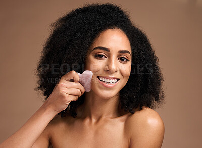 Buy stock photo Woman, studio portrait and crystal guasha for skincare, smile or cosmetic facial massage by backdrop. Black woman, model and self care with rose quartz stone for face glow, skin wellness or aesthetic