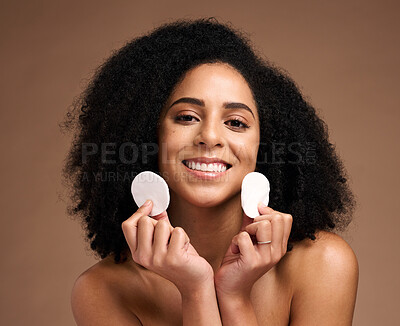 Buy stock photo Skincare, face portrait and black woman with cotton in studio isolated on a brown background. Cosmetics, wellness and happy female model holding facial pad or product for cleaning makeup for hygiene.