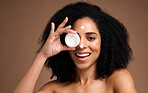 Face, skincare and black woman with cream container in studio on a brown background. Makeup cosmetics, portrait and female model apply facial lotion, product or moisturizer creme for healthy skin.