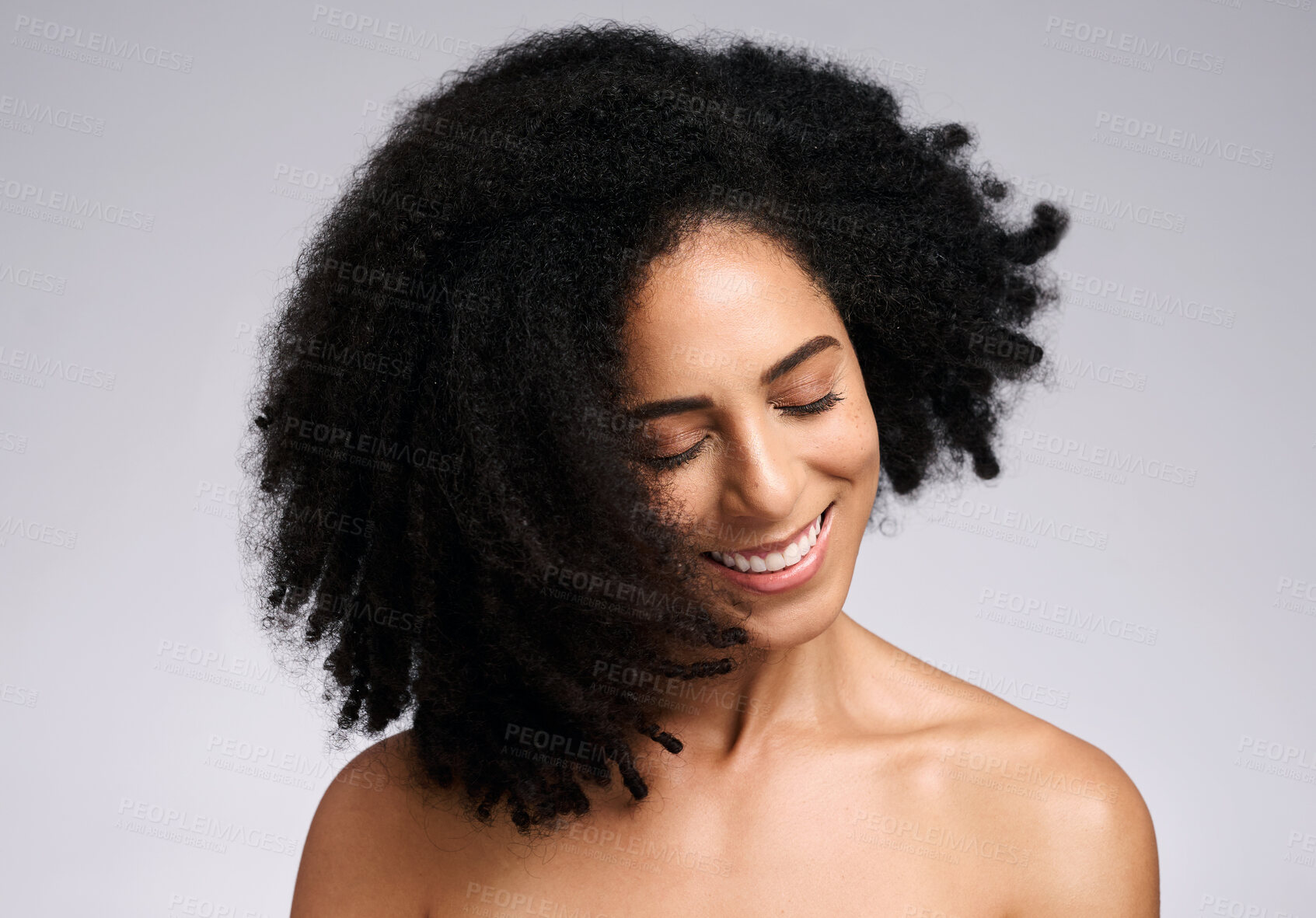 Buy stock photo Happy, natural and hair care shake of black woman satisfied with cosmetic treatment texture and volume. Self love, smile and happiness of african hair and skincare girl in gray studio background.