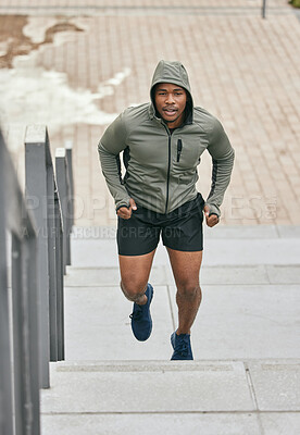 Buy stock photo Fitness, runner or black man running on steps in exercise, training or cardio workout in Chicago. Mission, mindset or healthy athlete in hoodie with motivation or sports goals exercising on stairs