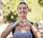 Portrait, woman and heart shape in nature while outdoor for freedom, love and support for summer travel adventure. Happy young female with hand sign and backpack for motivation, peace and wellness