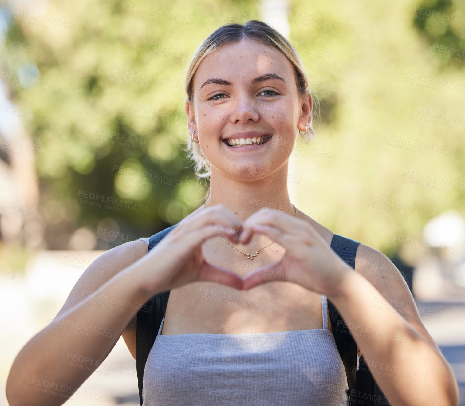 Buy stock photo Portrait, woman and heart shape in nature while outdoor for freedom, love and support for summer travel adventure. Happy young female with hand sign and backpack for motivation, peace and wellness