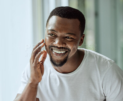 Buy stock photo Face, antiaging and skin with a black man looking in the bathroom mirror during his morning routine at home. Skincare, beauty and reflection with a handsome male grooming for wellness or natural care