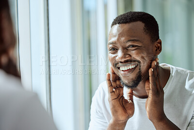 Buy stock photo Beauty, face and skincare with a black man looking in the bathroom mirror during his morning routine at home. Skin, head and reflection with a handsome male grooming for wellness or natural care