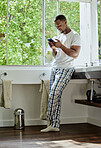Home, phone and black man in bathroom on social media, texting or internet browsing. Relax, cellphone or happy male holding mobile smartphone for web scrolling, networking or messaging alone in house