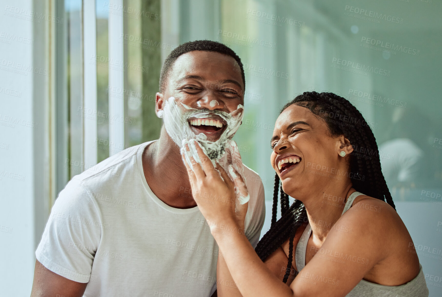 Buy stock photo Skincare wellness, happy couple in bathroom and shaving face with product for facial treatment. Laughing together in home, natural beauty and funny girlfriend helping black man with cream application