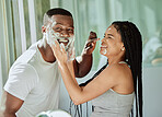 Shaving, playful and fun with a black couple laughing or joking together in the bathroom of their home. Love, shave and laughter with a man and woman being funny while bonding in the morning