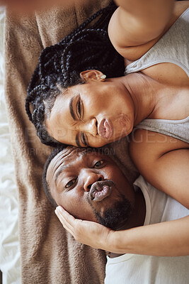 Buy stock photo Black couple, love and bedroom selfie while happy and funny together, pouting on bed at home, apartment or hotel. Portrait of a young man and woman in a happy marriage with commitment in top view