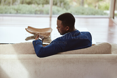 Buy stock photo Time, businessman and waiting on a sofa for appointment, meeting or property showing. Watch, realtor and black man sitting in a living room, timing, schedule and new house property investment 