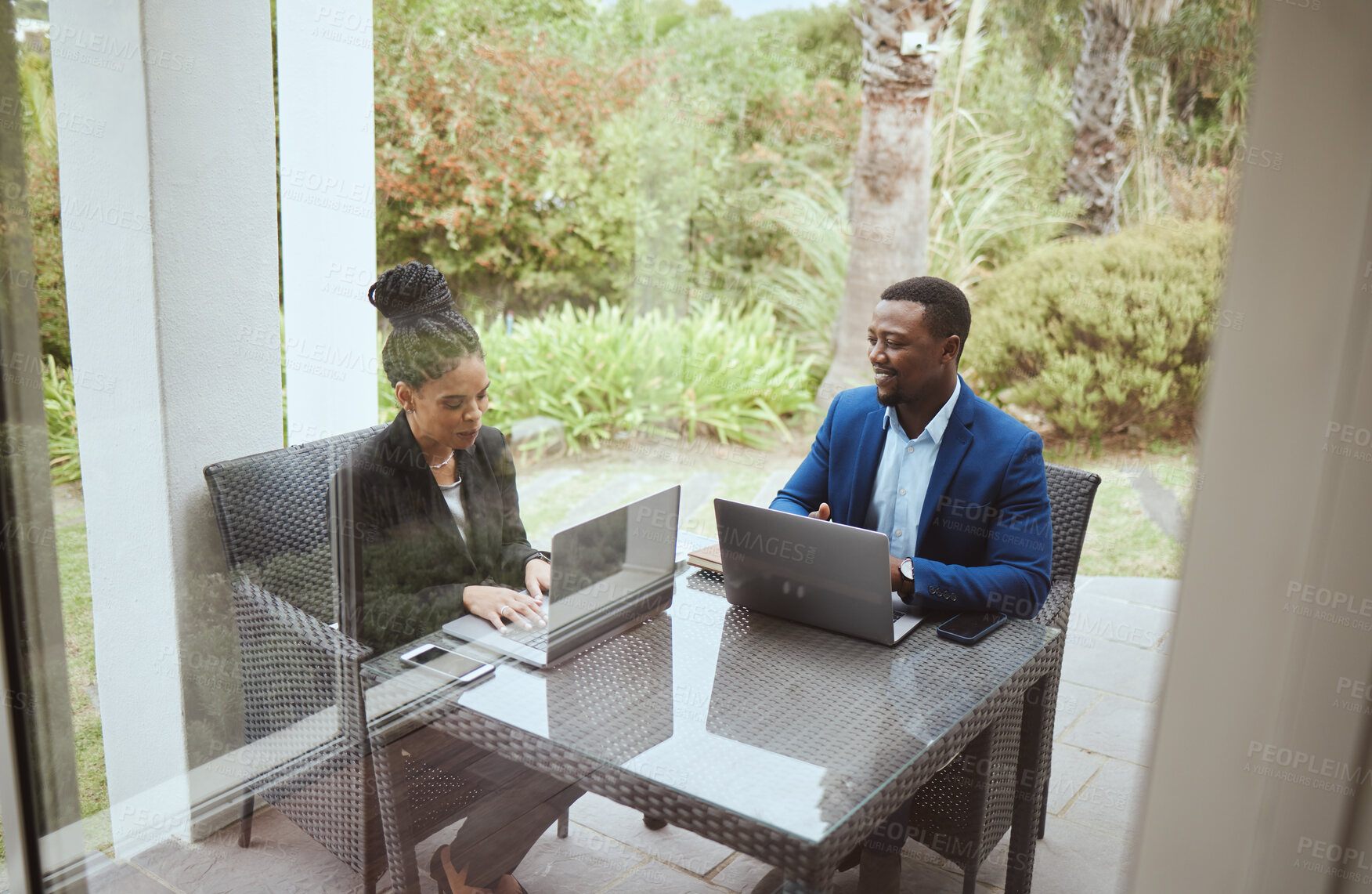 Buy stock photo Business people, man and black woman in meeting on terrace, laptop and finance goal on business trip. Black man, woman and teamwork in morning business meeting on patio, hotel or garden for planning