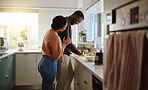 Black couple, cooking and helping with food in kitchen at home while together to cook healthy food. Happy young man and woman in their house or apartment to bond and prepare lunch or dinner with love