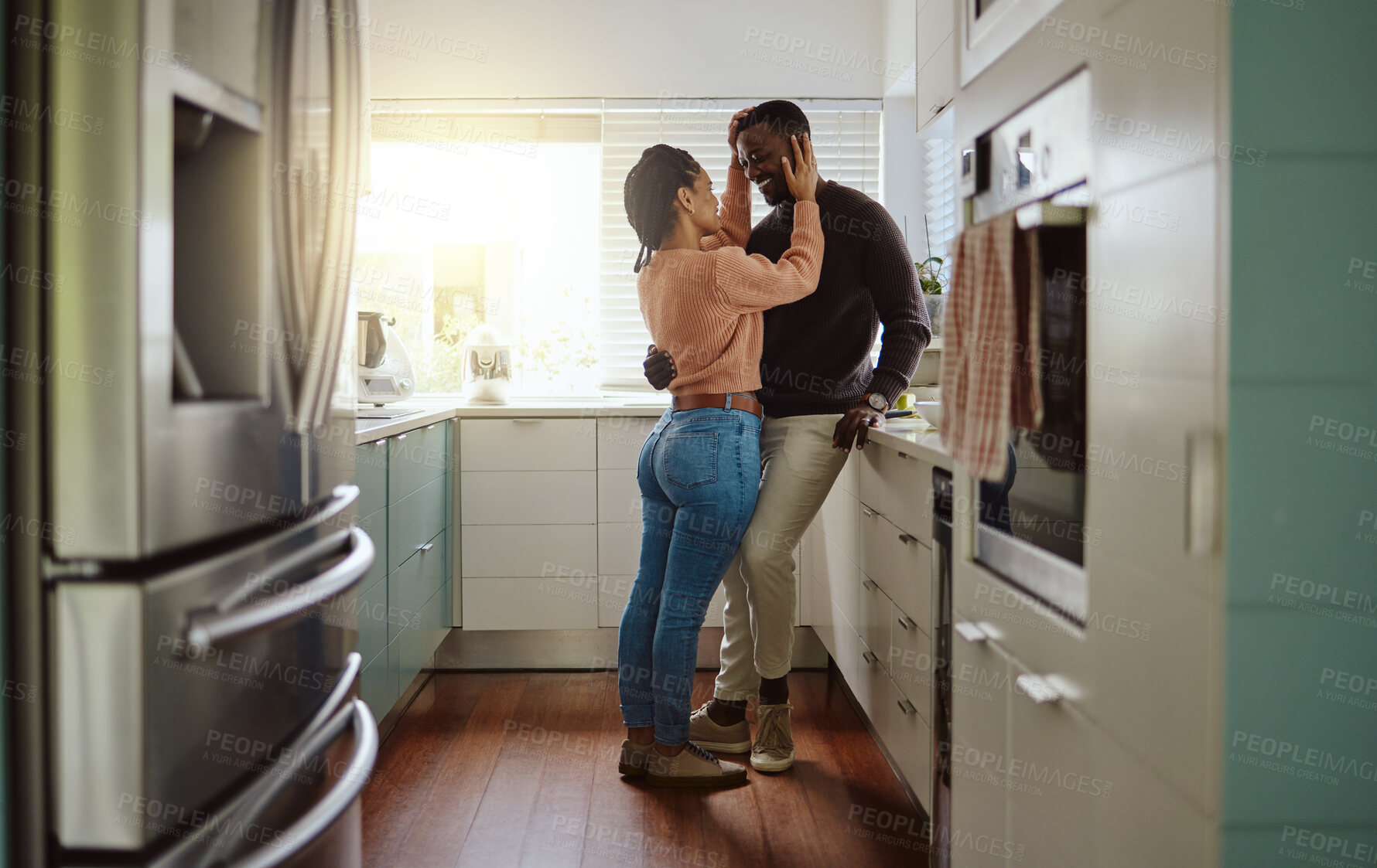 Buy stock photo Black couple, love and bonding in the kitchen at home with care and happiness in a marriage with commitment. Young man and woman together with a romantic hug while in their house or apartment