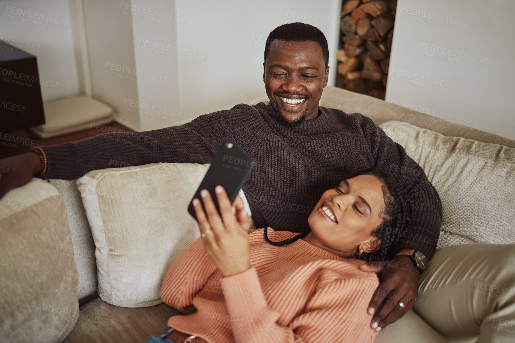 Buy stock photo Black couple, phone and funny social media post while together on living room couch with home wifi for internet. Man and woman talking and laughing while streaming online, ecommerce or mobile app