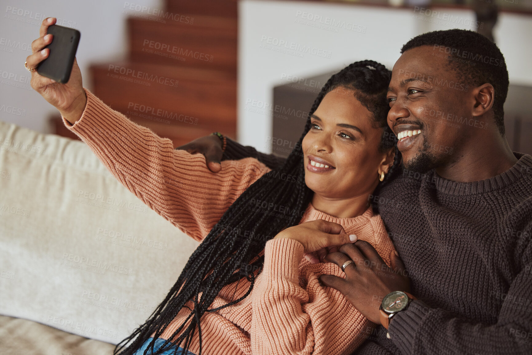 Buy stock photo Black couple,  phone selfie and love while together on home couch with care and happiness in a happy marriage. Young man and woman with a smile for social media while bonding in an apartment lounge 