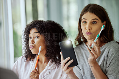 Buy stock photo Phone selfie, face and friends brushing teeth, goofy routine and morning social media update in a bathroom. Crazy, flash photo and women with toothbrush for dental care and mobile for picture