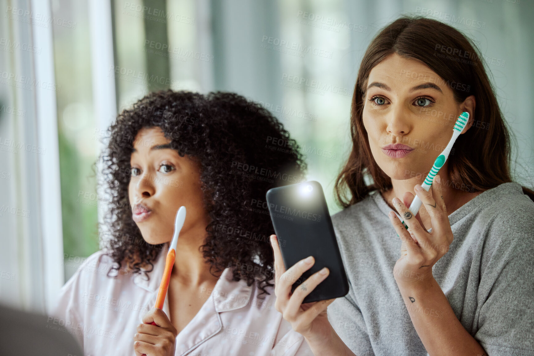 Buy stock photo Phone selfie, face and friends brushing teeth, goofy routine and morning social media update in a bathroom. Crazy, flash photo and women with toothbrush for dental care and mobile for picture