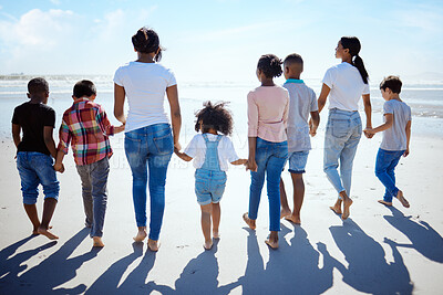 Buy stock photo Big family, beach walk and summer for holiday, sunshine and bonding with interracial diversity by water. Happy family, lesbian mom and holding hands for solidarity, care and love on vacation by sea
