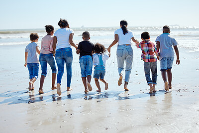 Buy stock photo Big family, beach walk and water for vacation, sunshine and bonding with interracial diversity by waves. Happy family, mother and holding hands for solidarity, care and love on holiday by sea