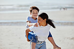 Mother, beach piggyback and asian child with smile, family bonding and outdoor vacation in sunshine. Happy family, interracial and ride on woman back for adoption, love and game by ocean for holiday
