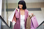 Woman, shopping and mall escalator with a paper bag for retail therapy, sale and customer discount at a store. Travel, fashion and female excited about clothes, discount and commercial promotion