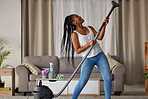 Vaccum, living room and fun with a black woman cleaner in her home for cleaning or housework. Dance, happy and hygiene with a young female in her apartment for housekeeping using an appliance