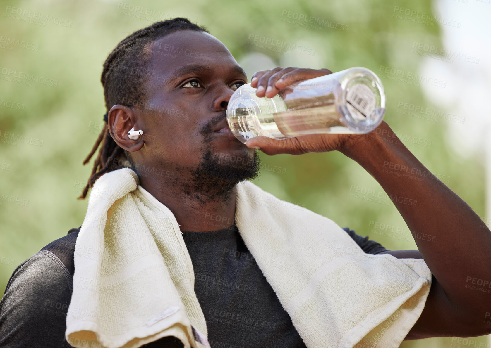 Buy stock photo Water, fitness break and black man running in nature, exercise hydration and focus on body performance in Germany. Thirsty, training and African runner thinking of cardio workout in park with a drink