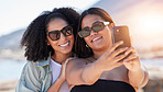 Women, lgbtq and phone selfie at beach for love, travel and care on summer holiday, vacation or freedom. Sunglasses, lesbian and happy couple of friends taking mobile photograph, sea and social media