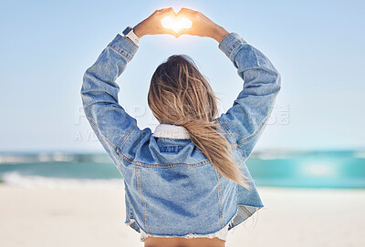 Buy stock photo Heart, hands and back view of woman at beach love, care and kindness, trust and support. Girl, sea and finger shape for wellness, nature and peace for earth day, blue sky and ocean travel in sunshine