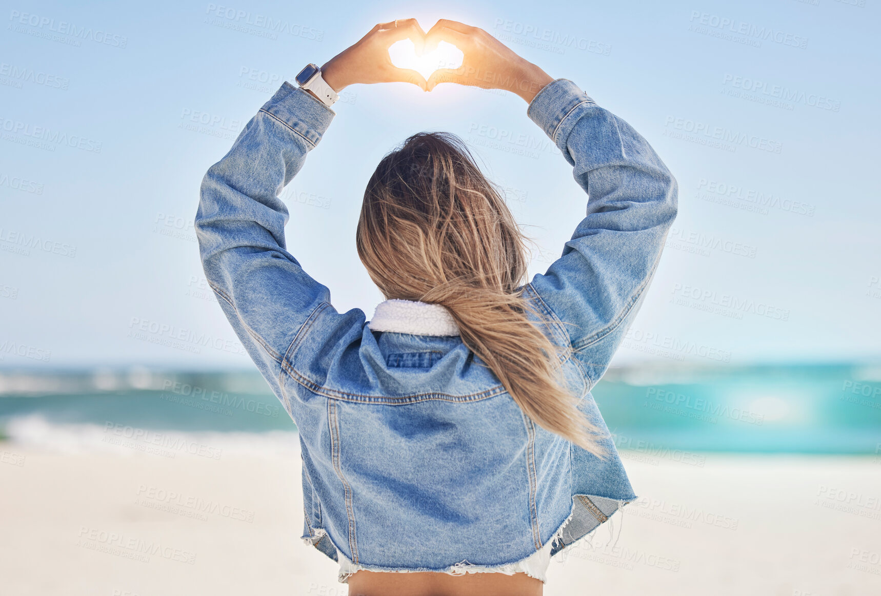 Buy stock photo Heart, hands and back view of woman at beach love, care and kindness, trust and support. Girl, sea and finger shape for wellness, nature and peace for earth day, blue sky and ocean travel in sunshine