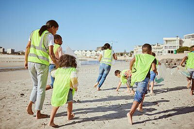 Buy stock photo Woman and group of children cleaning beach for volunteering, community and charity with earth day, climate change and education. Friends, teacher volunteer and recycle plastic for pollution learning