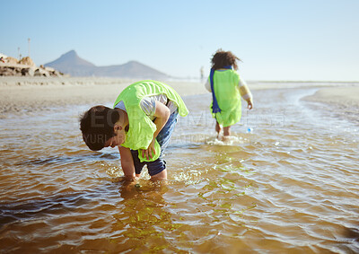 Buy stock photo Ocean, environment and young child cleaning for climate change and sustainability, environmental and volunteer for Earth day. Water pollution, nature and kids clean up beach and eco friendly activism