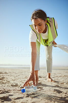 Buy stock photo Volunteer, charity and beach cleanup with a black woman picking up plastic bottle garbage from the sand. Recycle, cleaning or earth day with a female going green for the environment or sustainability