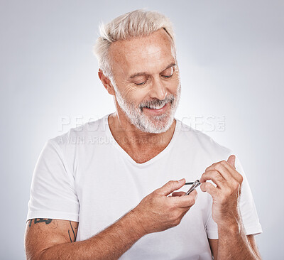 Buy stock photo Nail clippers, beauty and grooming with a man in studio on gray background mockup to pamper, cutting his finger nails. Manicure, wellness or cosmetics with a male taking care of his personal hygiene