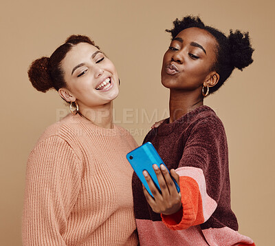 Buy stock photo Selfie, friends and women with smartphone, social media and connection on brown studio background. Females, girls and cellphone to share photos, posting and bonding together casual, trendy and smile