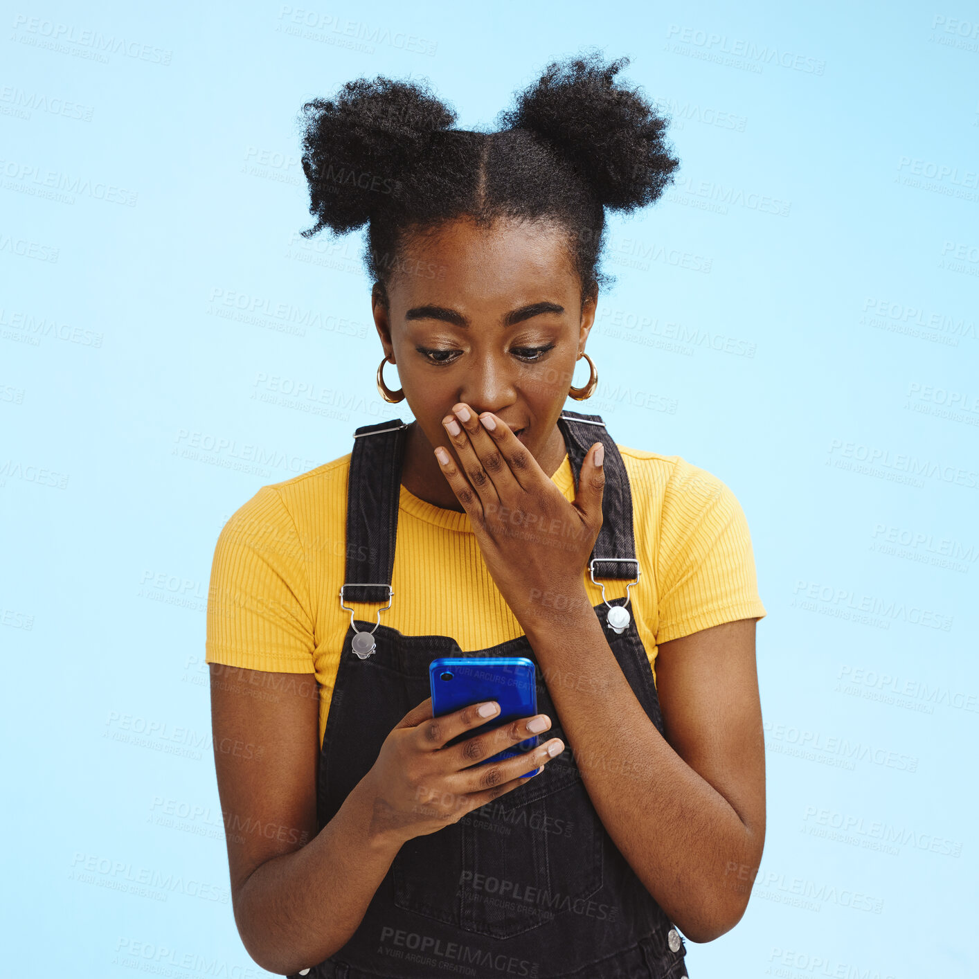 Buy stock photo Wow, gossip and shocked black woman isolated on blue background for social media, fake news or post update. Smartphone, surprise notification and people, gen z or person reading text in studio mockup