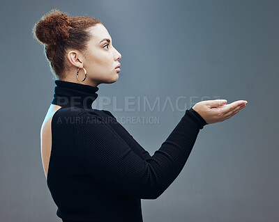 Buy stock photo Hand, woman and holding gesture in studio with mockup, space and grey background for product placement. Young, beautiful and girl with open palm hands on mock up, branding and showing copy space